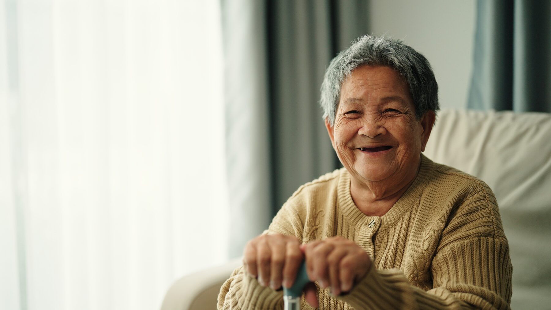 Résidente souriante près de la fenêtre, lumière douce